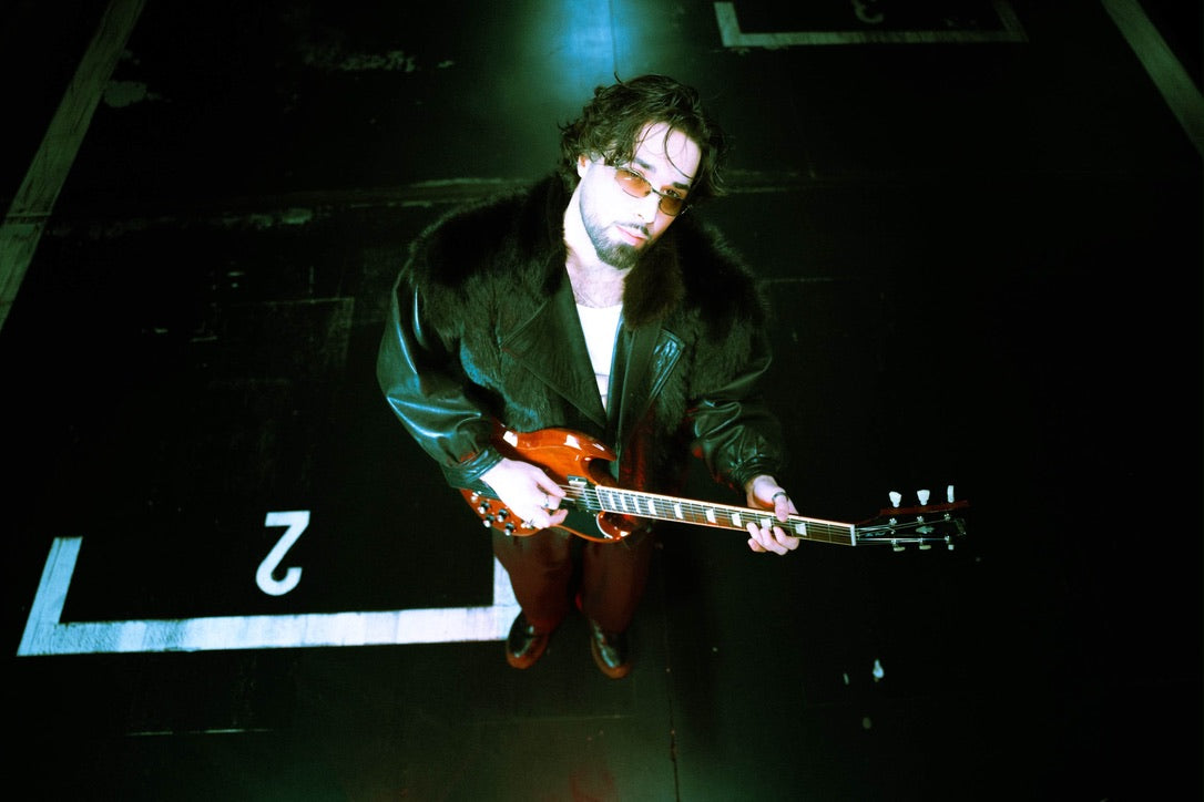 D. LATORRE photographed from above holding a Gibson SG
